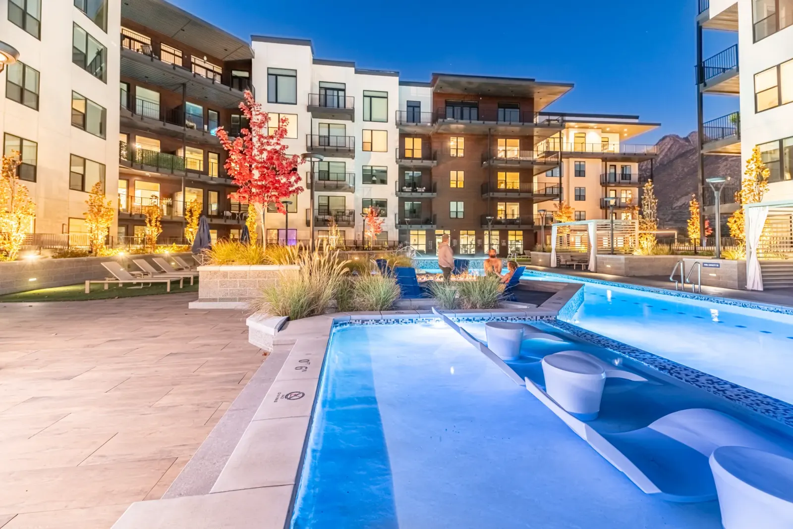 Grandeur pool and spa at dusk with fire-trough seating