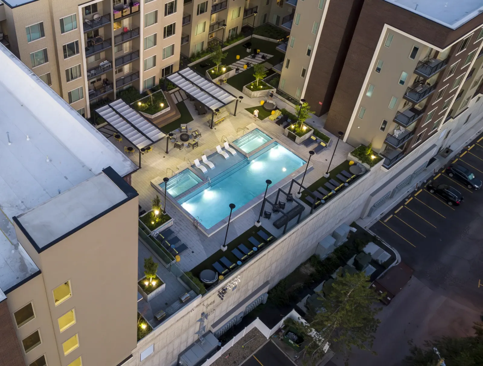 Aerial of the Park Avenue rooftop pool terrace glowing at dusk, Sugar House District