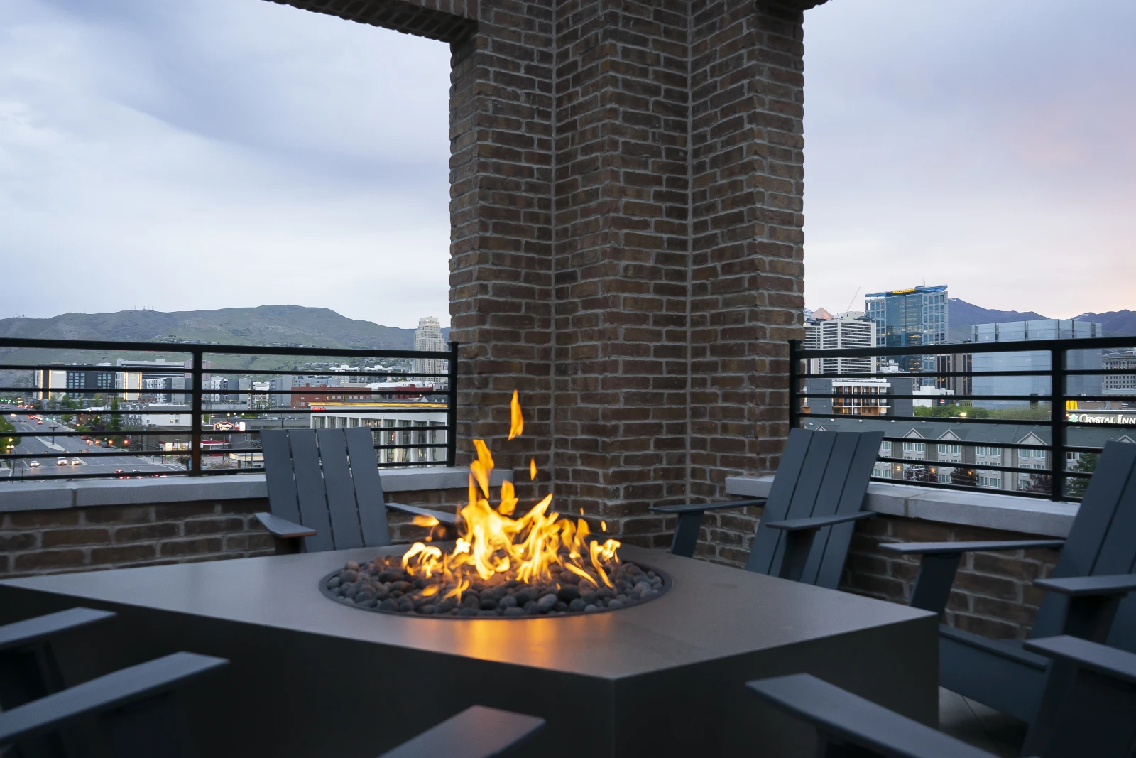 Post House rooftop firepit and seating at dusk with the city beyond