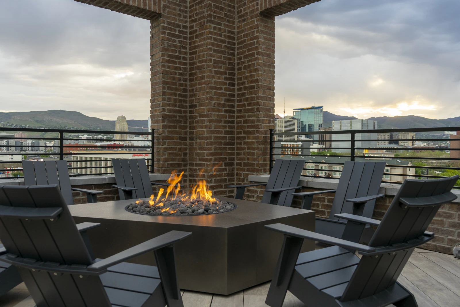 Post House rooftop fire pit with four Adirondack chairs at golden hour