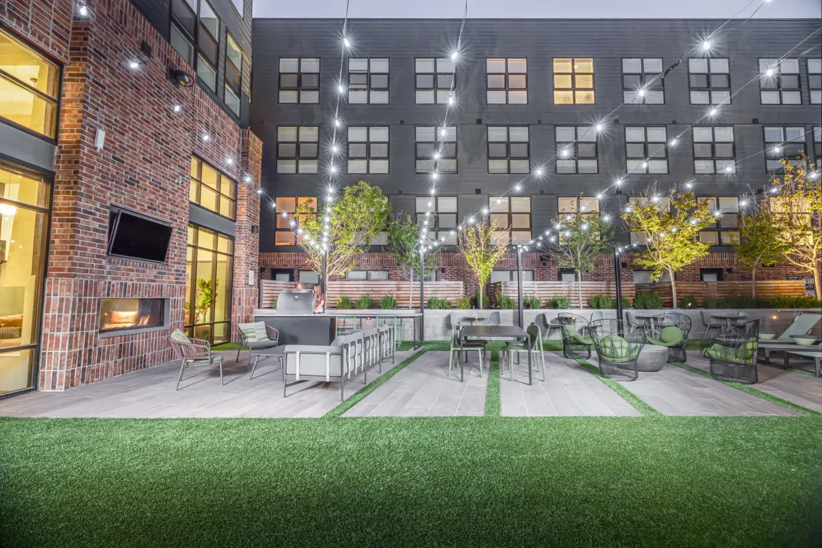 A twilight courtyard strung with festoon lights at Slate, a Loft Six Four rooftop