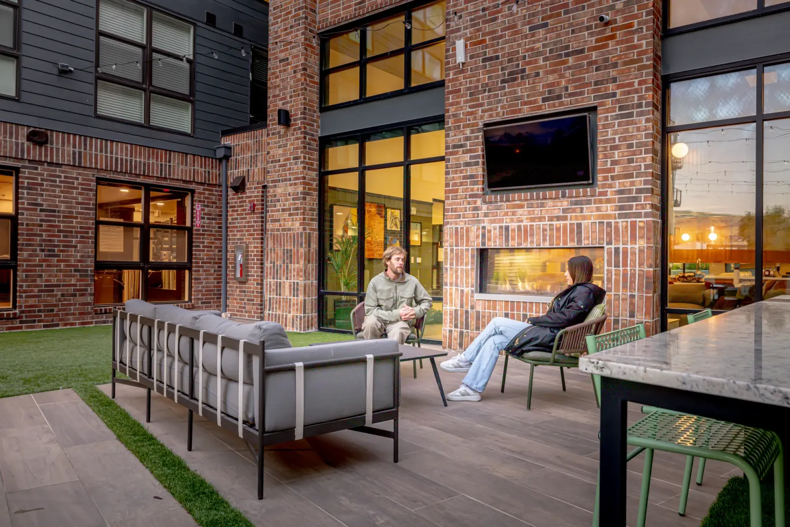 Residents talking beside the Slate courtyard fireplace at twilight